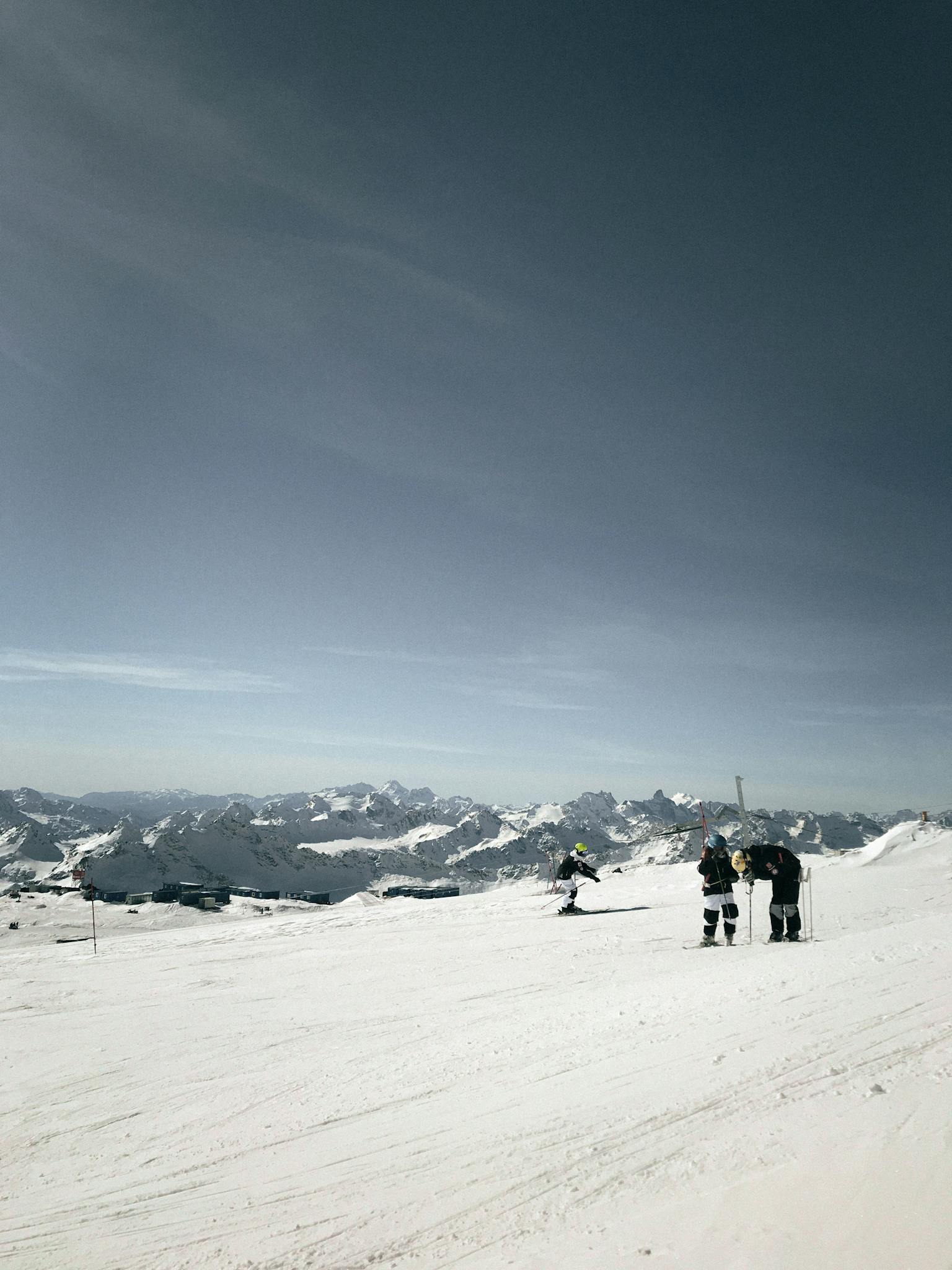 A scenic winter landscape with skiers enjoying a day on snowy slopes under a clear sky.