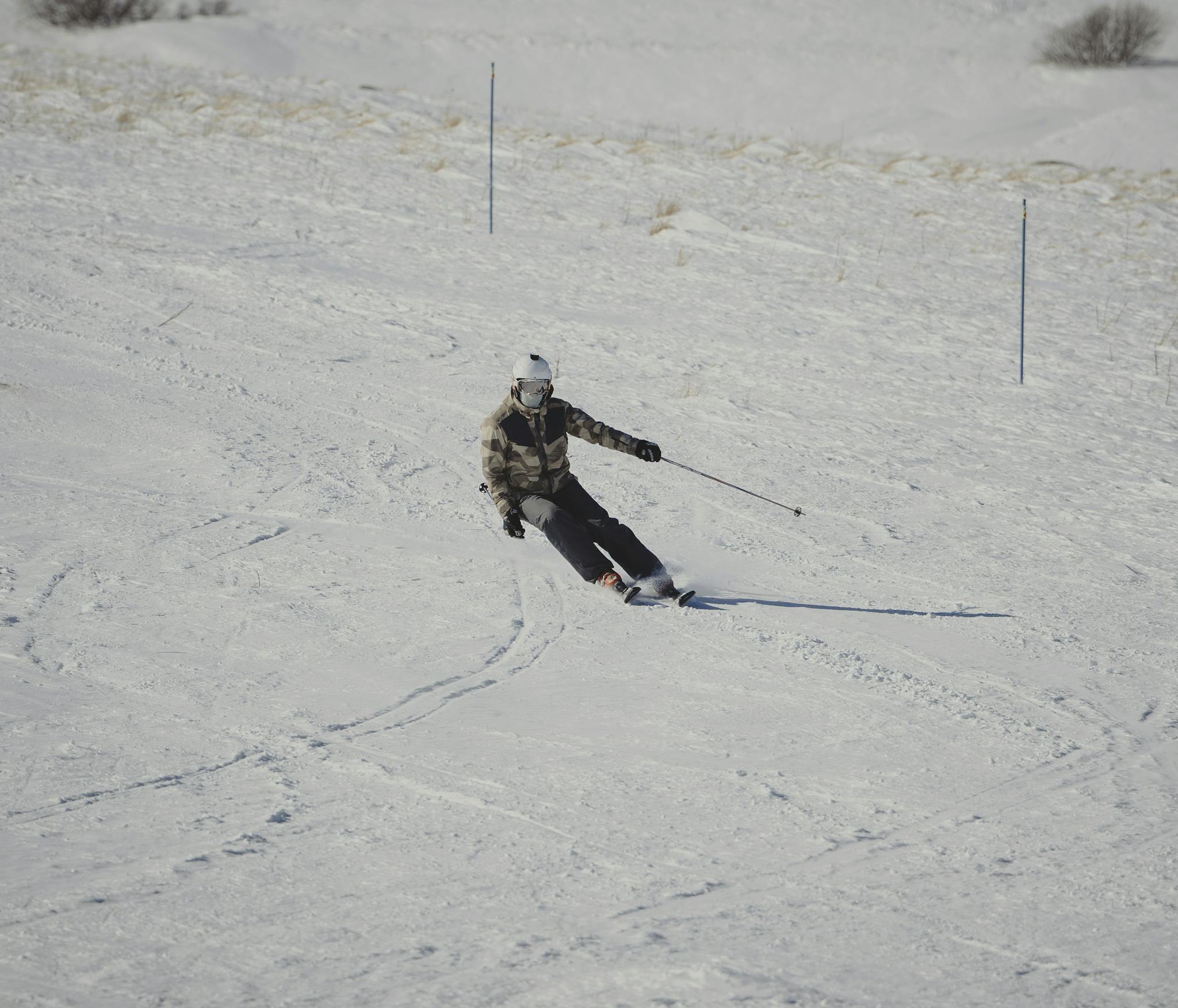 A skier elegantly glides down a snowy mountain slope in winter conditions.