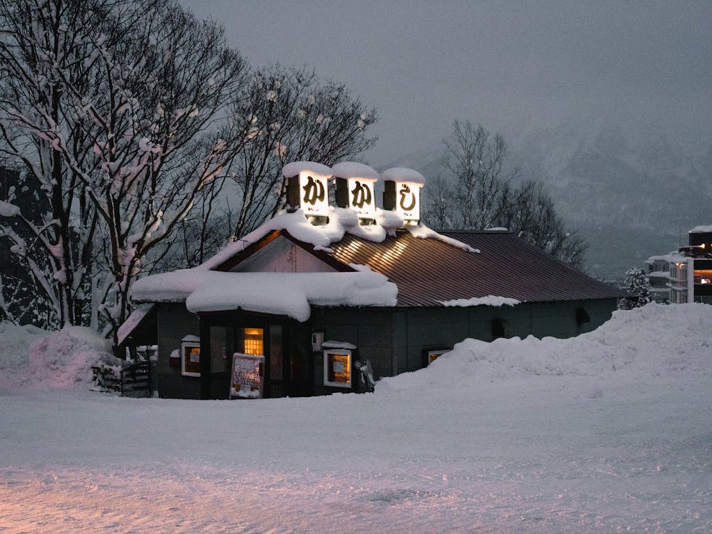 Snow-covered restaurant in snowy winter evening in Niseko, Hokkaido. Charming seasonal scene.