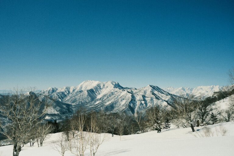 Stunning view of snow-covered mountains with clear blue sky in Japan.